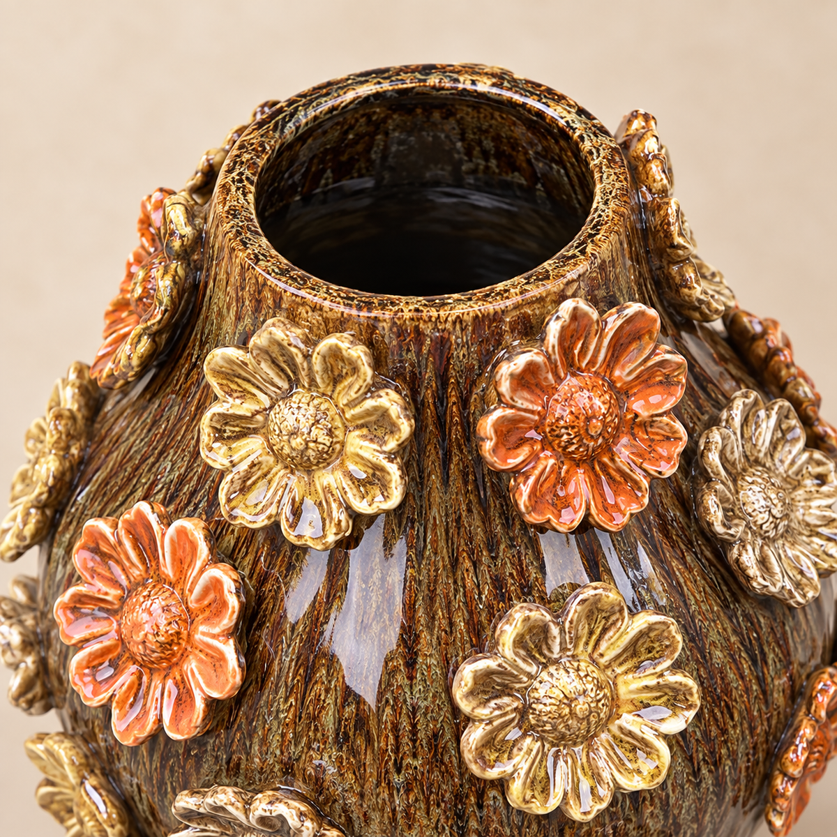 Close-up of handcrafted brown ceramic vase with colourful 3D floral embellishments and reactive glazed finish.