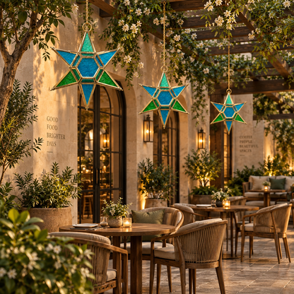 Blue and green stained glass hanging star lantern suspended beneath a luxury outdoor pergola in a premium patio setting, decorative handcrafted hanging lantern by Inara Home Decor.