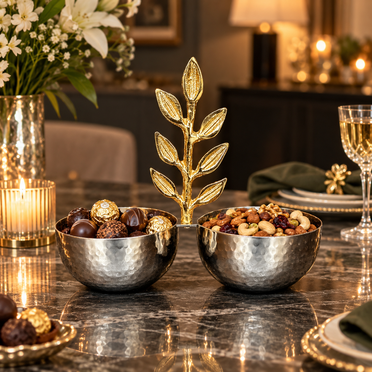 Inara luxury silver hammered double bowl filled with gourmet chocolates and mixed nuts set on an elegant marble dining table with candlelight and wine glasses.