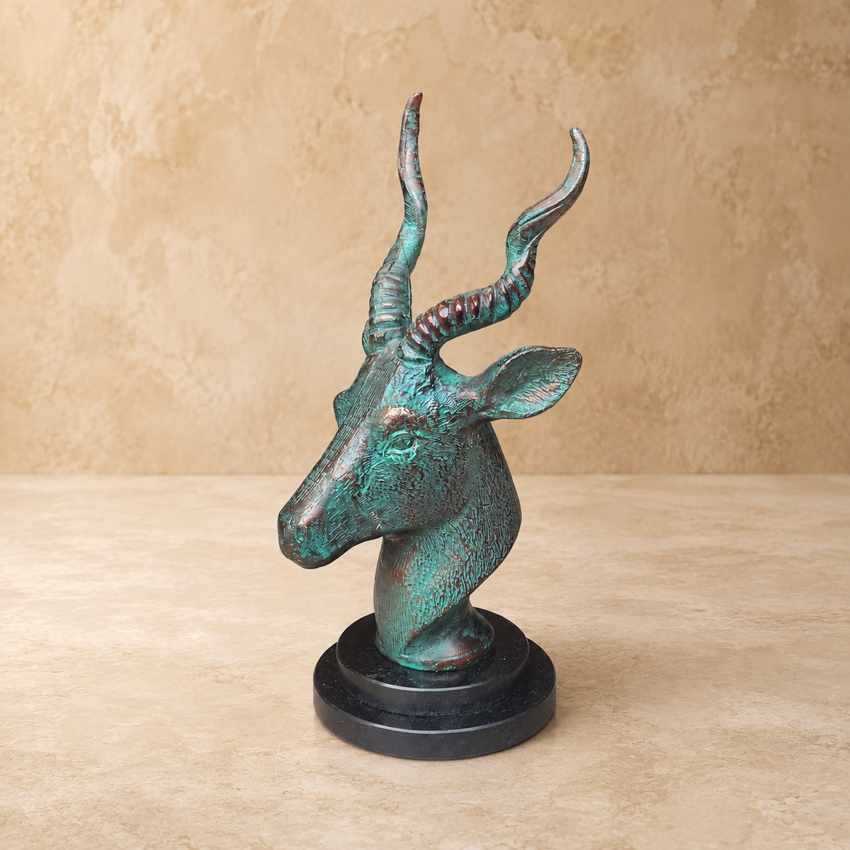 Side profile of handcrafted antique bronze deer head sculpture with textured finish and elegant black marble base for premium interior décor.