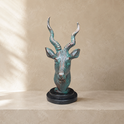 Front view of handcrafted antique bronze deer head sculpture on a polished black marble base, ideal for luxury home décor and office styling.
