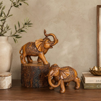 Decorative handcrafted elephant sculpture set styled on a wooden console table with elegant home accessories, creating a warm luxury living room interior.
