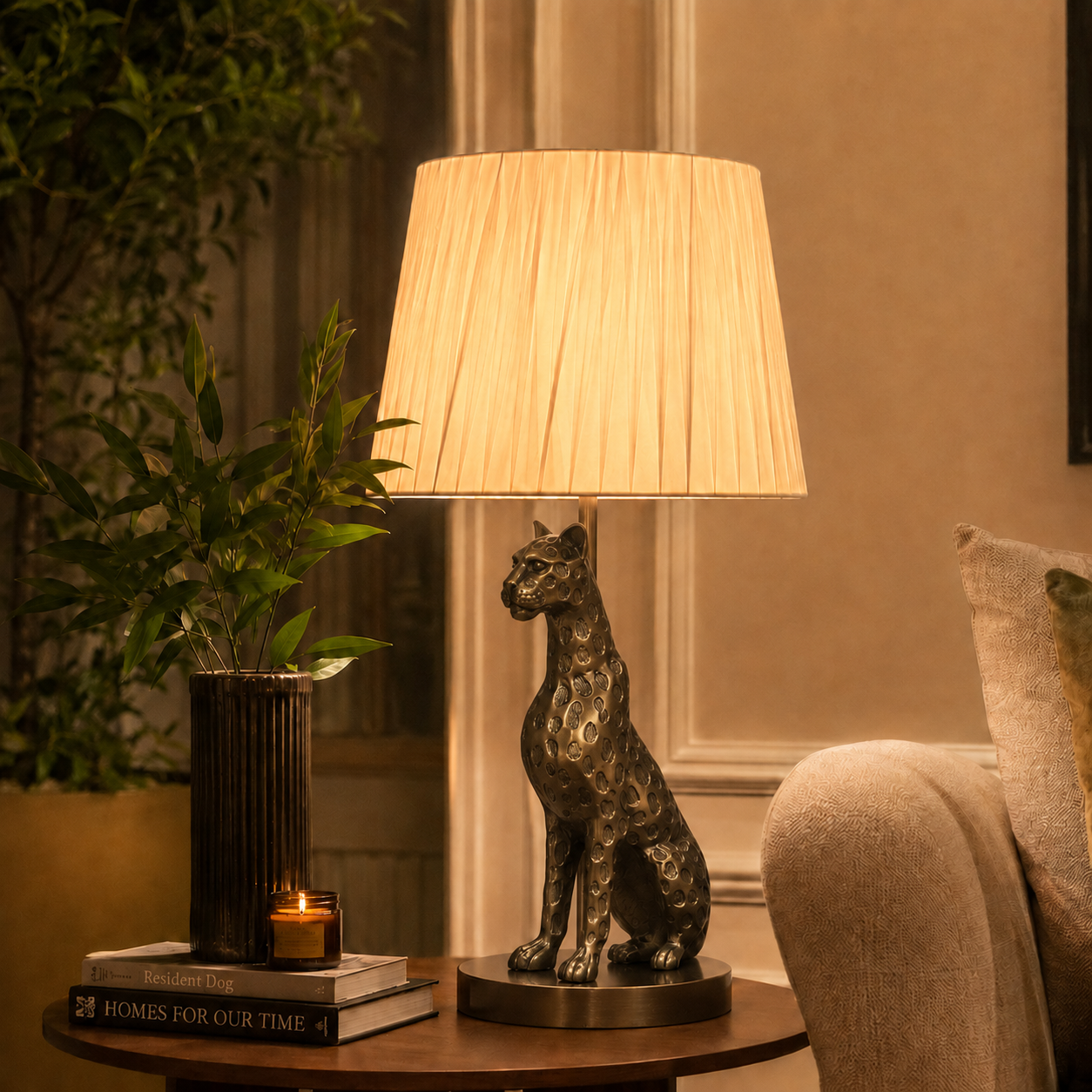 Luxury antique brass leopard table lamp with ivory pleated shade styled on a wooden side table in an elegant modern living room.