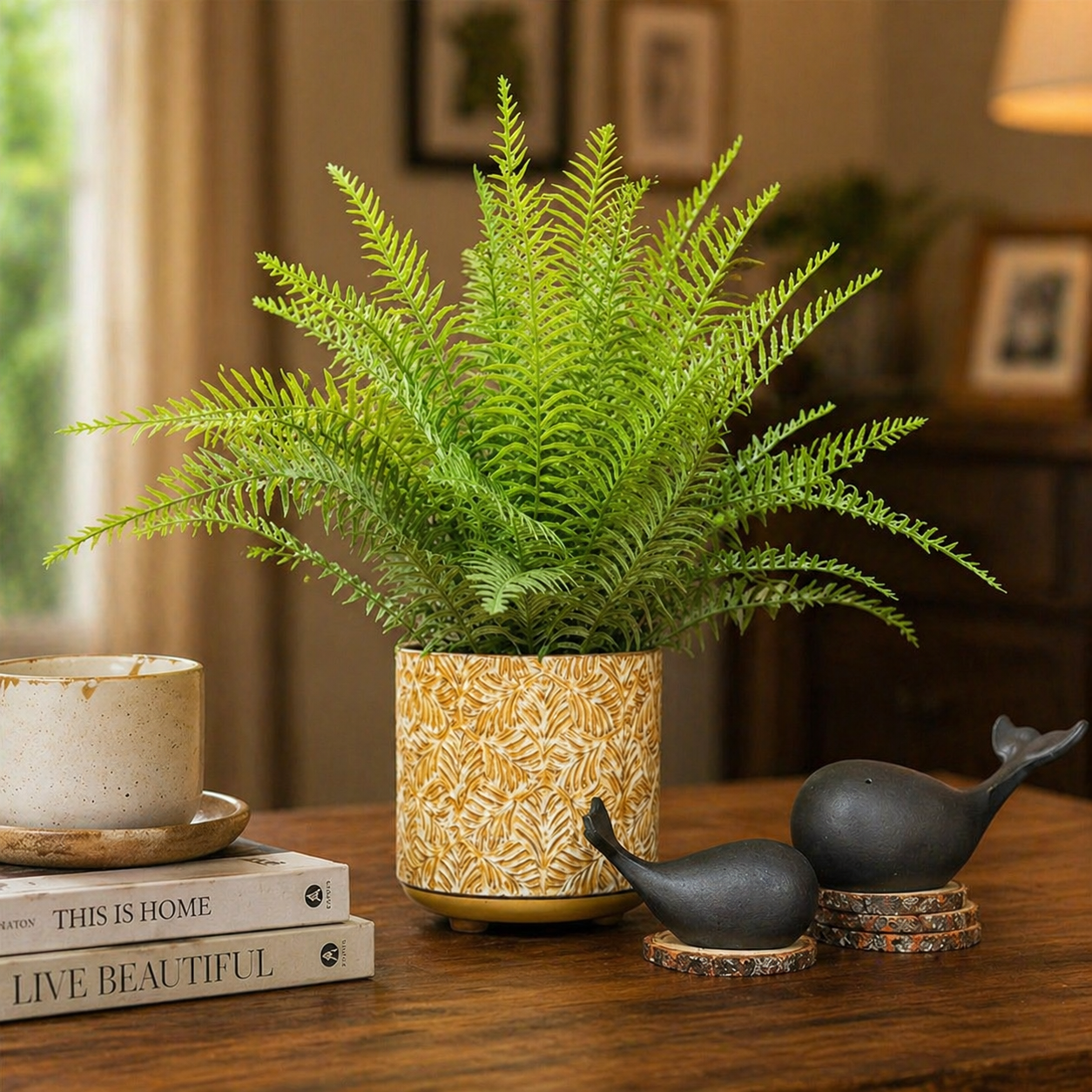 Luxury home decor arrangement featuring a hand-painted heritage ceramic pot and minimalist matte black whale sculptures in a warm, cozy interior setting.