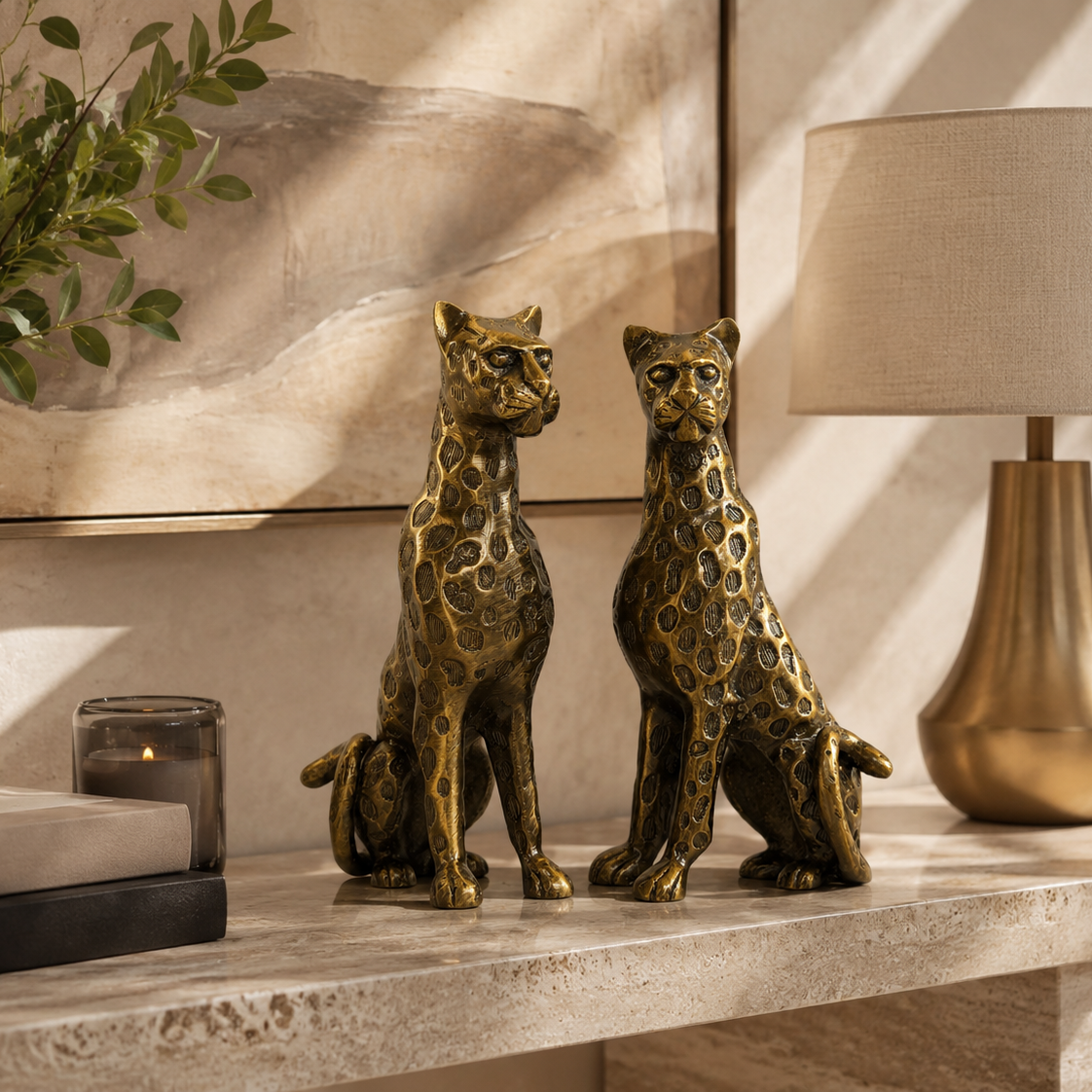 Luxury brass leopard pair sculpture displayed on a premium stone console with warm beige décor, designer lamp, and artwork, creating an elegant modern home styling scene.