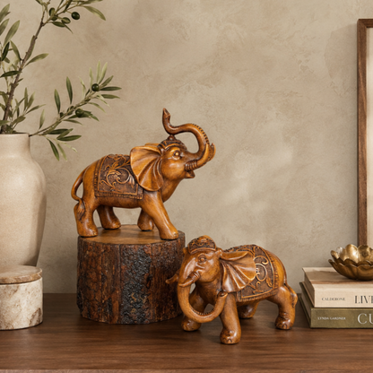 Decorative handcrafted elephant sculpture set styled on a wooden console table with elegant home accessories, creating a warm luxury living room interior.