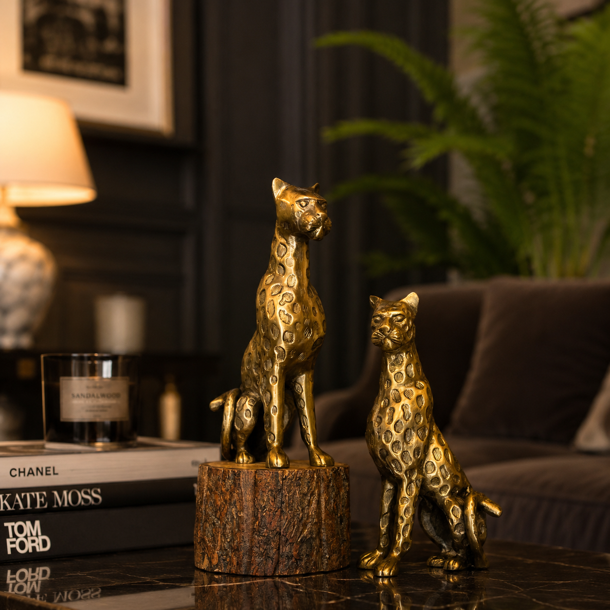 Luxury gold leopard sculptures styled on a polished coffee table with designer books, a scented candle, and elegant living room décor, creating a sophisticated modern interior aesthetic.