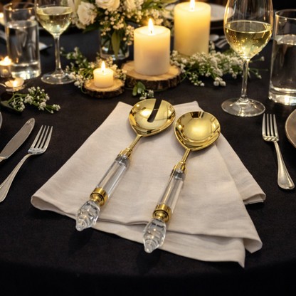 Luxury gold salad serving spoon and fork with clear acrylic handles styled on an elegant candlelight dinner table with wine glasses and floral décor
