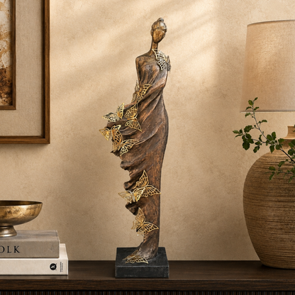Luxury lady butterfly sculpture styled on a dark wooden console table in a premium living room with a warm beige Venetian plaster wall, showcasing elegant modern home décor by Inara Home Decor.
