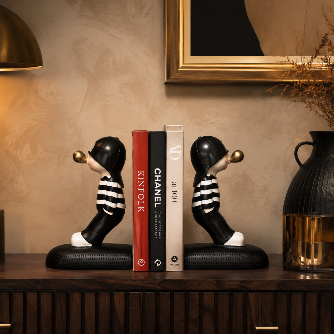Boy bookends styled on a walnut console table with books and decor accents