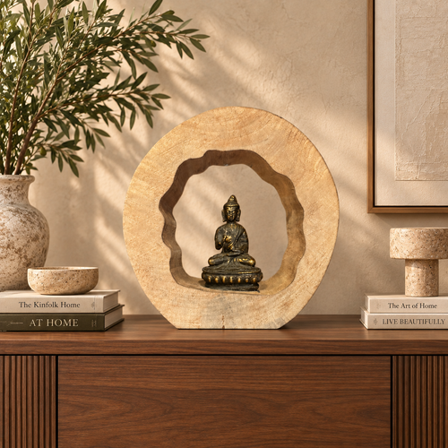 Handcrafted wooden Buddha meditation sculpture displayed on a walnut console in a luxury contemporary living room with warm neutral décor.