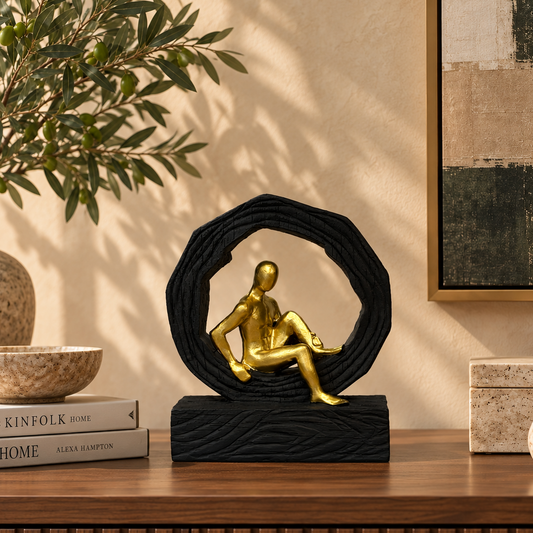 Modern abstract gold and black resin sculpture displayed on a walnut console table in a luxury living room with contemporary décor.