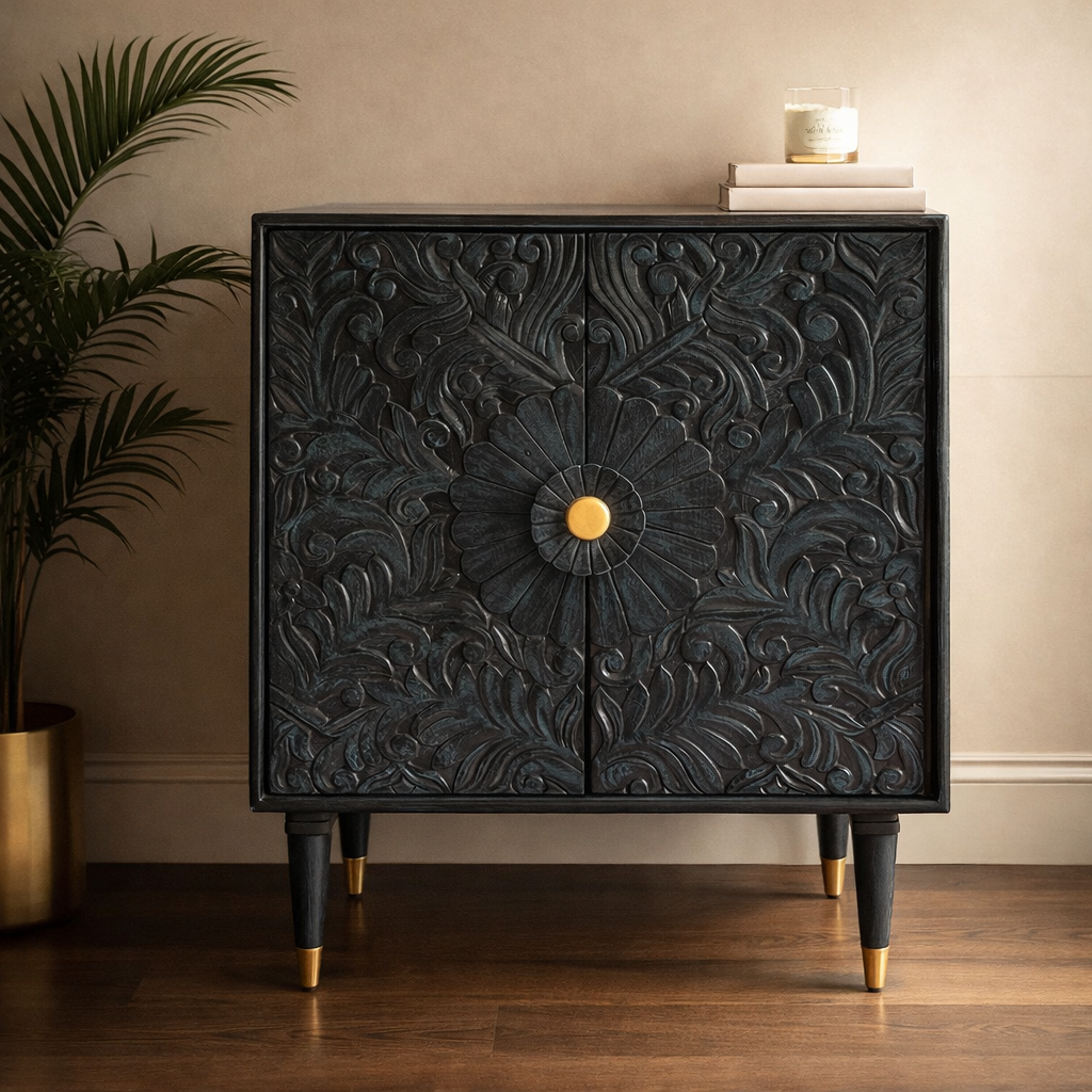 Modern teal carved wooden console cabinet with brass knob and tapered legs styled with books and candle in a contemporary interior.
