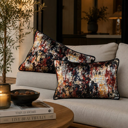 Abstract multicolor lumbar cushion covers styled on a beige sofa in a modern luxury living room, featuring artistic navy, rust, gold, and ivory patterns for elegant home décor.