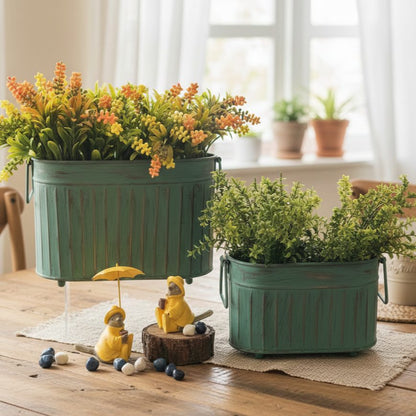 Vintage patina ribbed metal planter set with artificial greenery displayed on a wooden table in a bright luxury home interior.