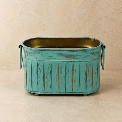 Front view of the handcrafted Vintage Patina Ribbed Metal Planter with distressed turquoise finish, decorative side handles, and antique brass interior on a neutral background.