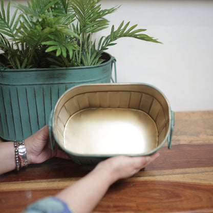 Handcrafted vintage patina metal planter showcasing its antique gold interior finish and decorative side handles.