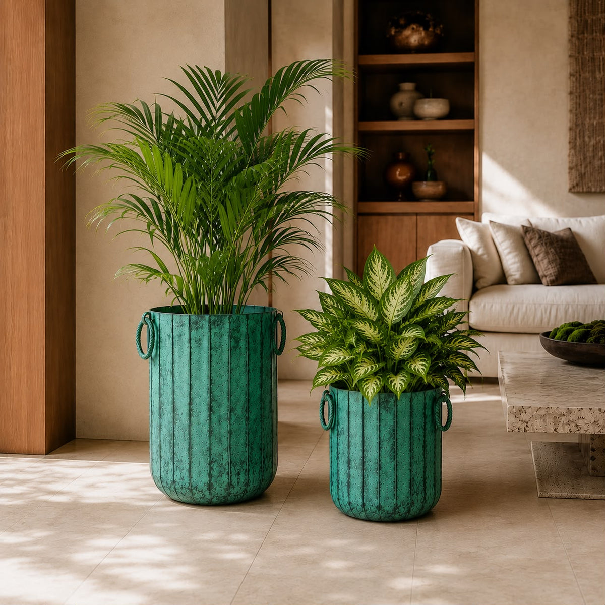 Luxury green metal planter set with tropical indoor plants styled in a modern living room with warm contemporary interiors.