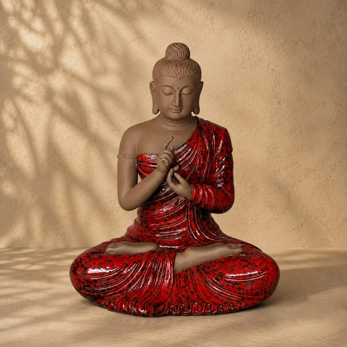 Hand-painted red Buddha statue with a serene matte finish and glossy robe, decorative ceramic sculpture for luxury home décor.