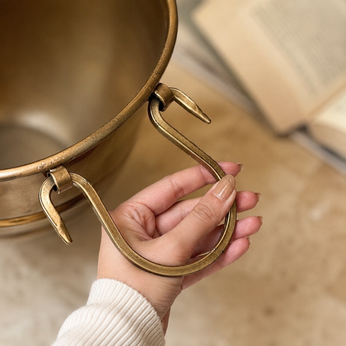 Close-up of handcrafted brass planter featuring decorative ring handles and premium antique brass finish.