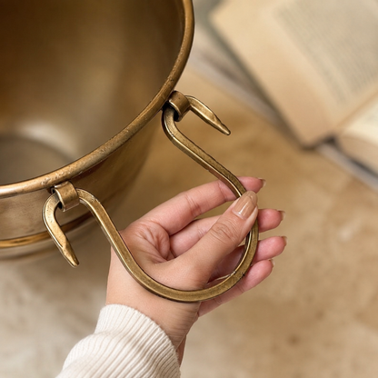 Close-up of handcrafted brass planter featuring decorative ring handles and premium antique brass finish.