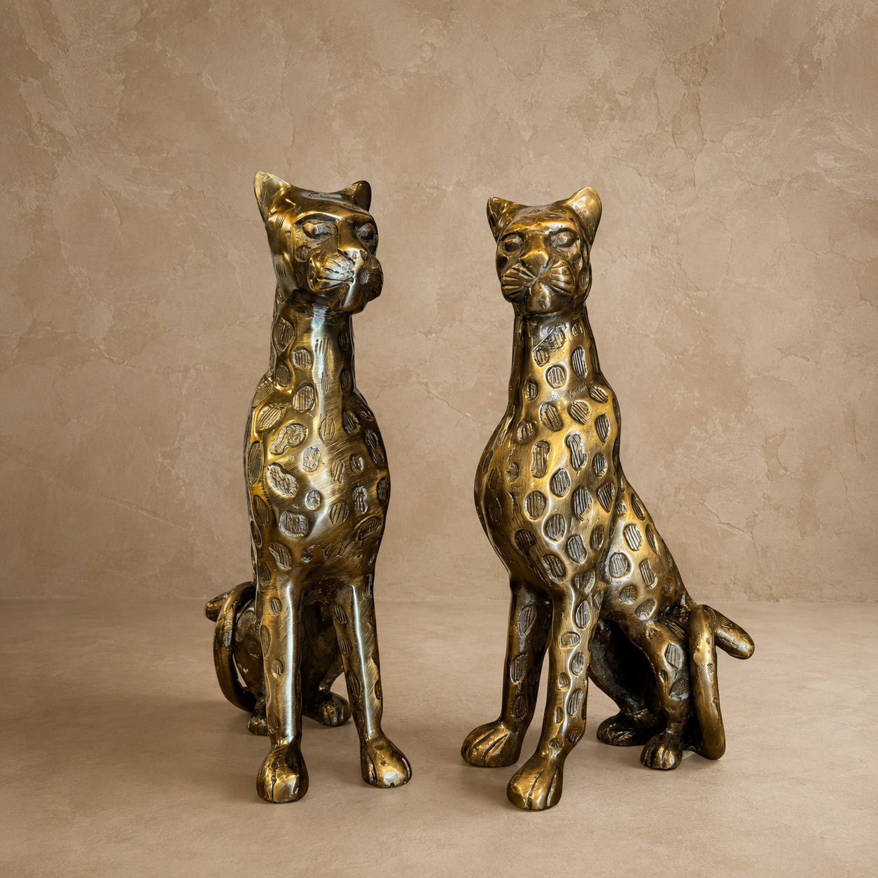 Premium antique brass leopard sculpture pair displayed against a warm beige Venetian plaster wall with a seamless microcement floor, luxury handcrafted animal figurines for elegant modern home décor.