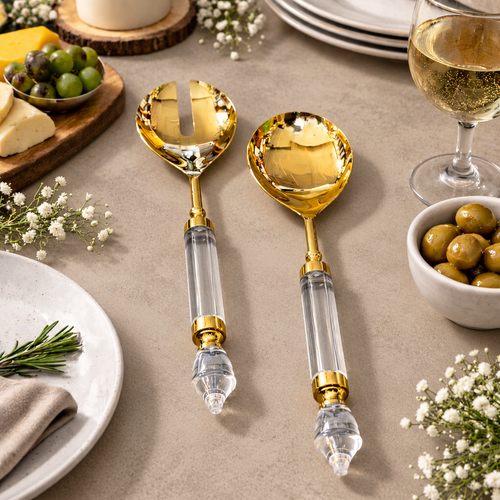 Luxury gold salad server set with clear acrylic handles styled on a rustic wooden dining table with olives, cheese, and wine, premium modern tableware décor