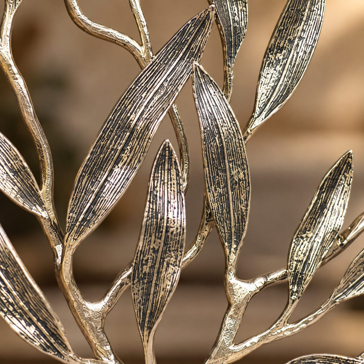 Close-up of premium textured metal olive tree sculpture showcasing intricate handcrafted leaf detailing and antique gold finish.