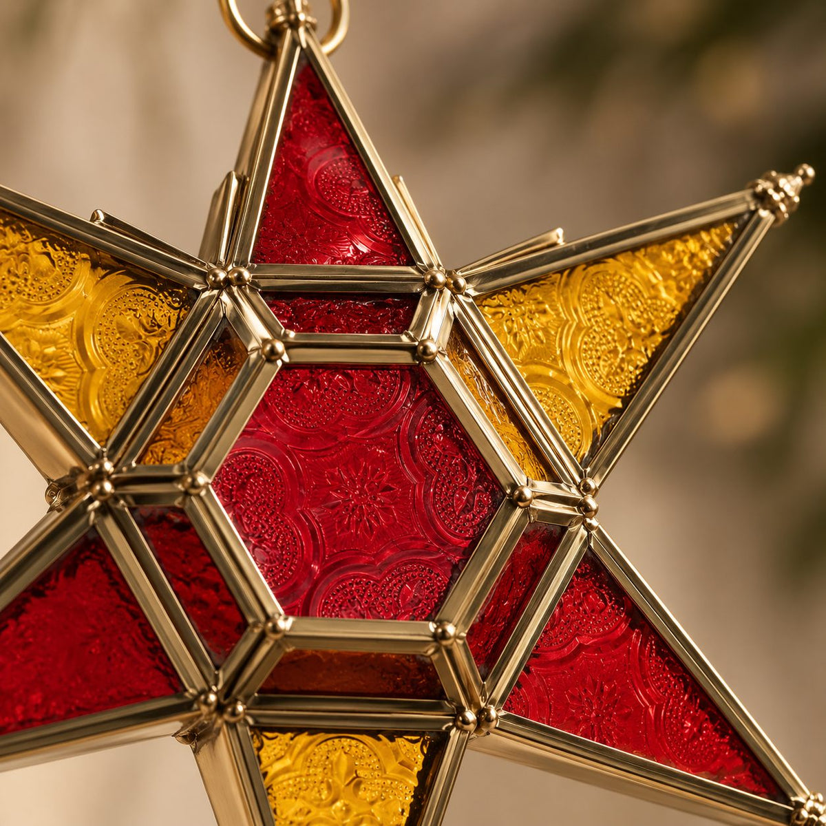 Close-up of handcrafted brass frame and textured red and amber stained glass star lantern showing premium craftsmanship.