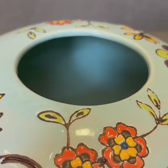 Close-up video showcasing the intricate handpainted floral detailing on an aqua green ceramic vase for luxury tabletop and home decor styling.