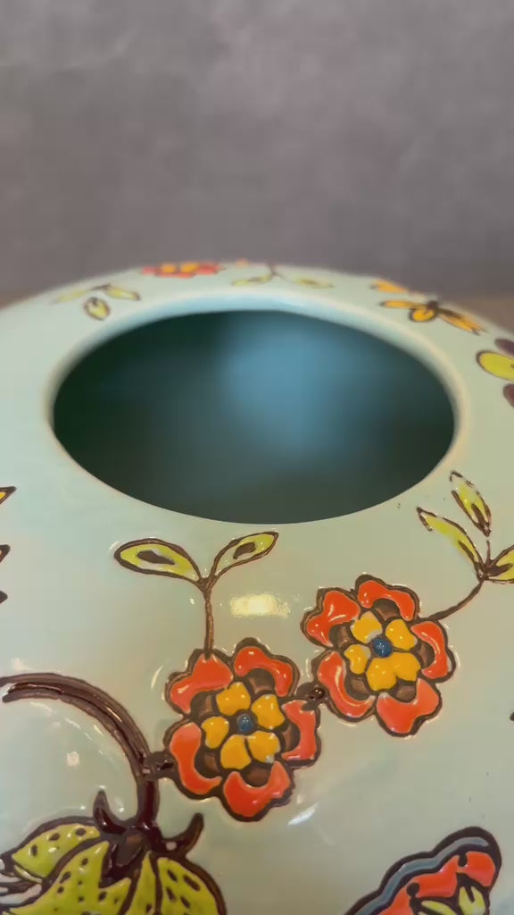 Close-up video showcasing the intricate handpainted floral detailing on an aqua green ceramic vase for luxury tabletop and home decor styling.