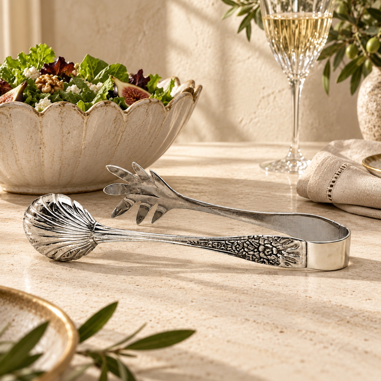 Premium handcrafted silver salad serving tongs with decorative engraved handles and polished stainless steel finish, elegantly showcased in a luxury dining setting while serving fresh salad. A timeless serving accessory for sophisticated table settings by Inara Home Decor.