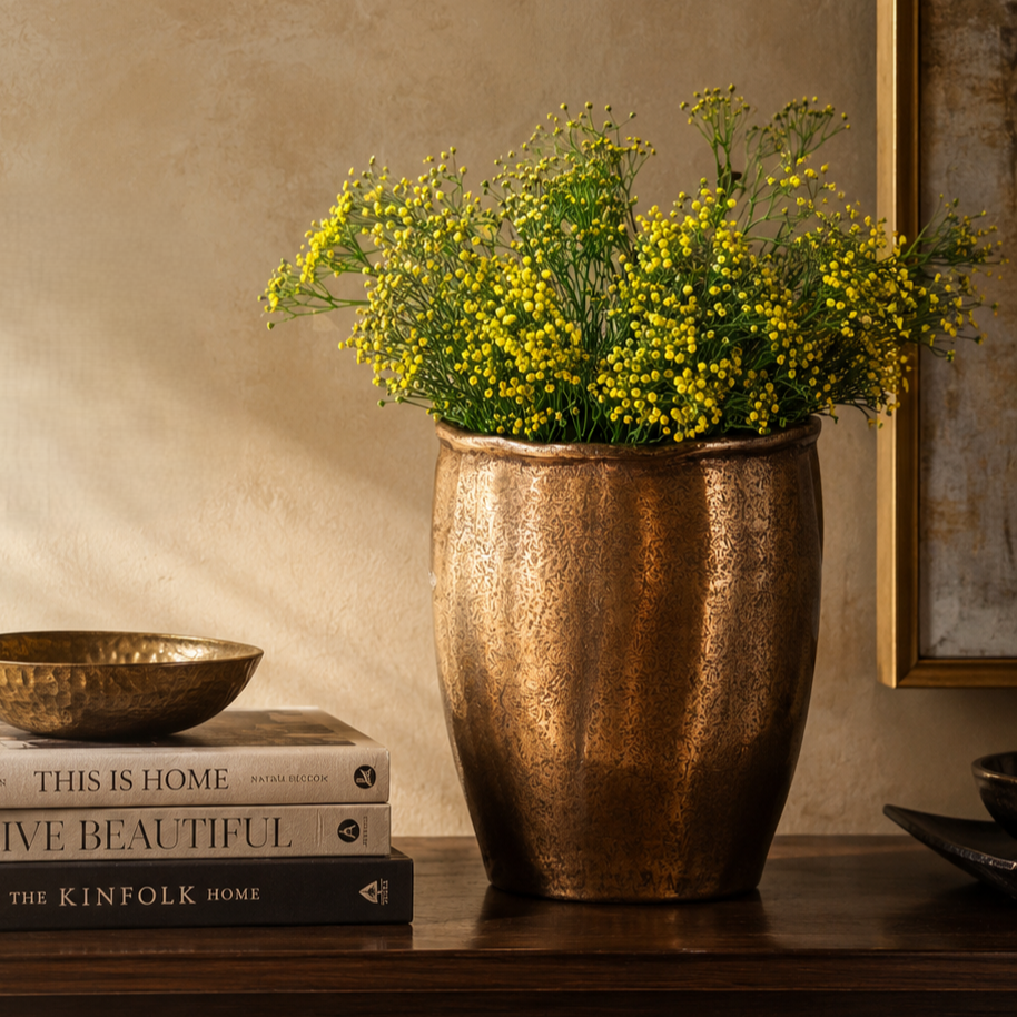 Time-lapse video of a florist arranging pink peonies and eucalyptus into a textured bronze vase on a wooden console table