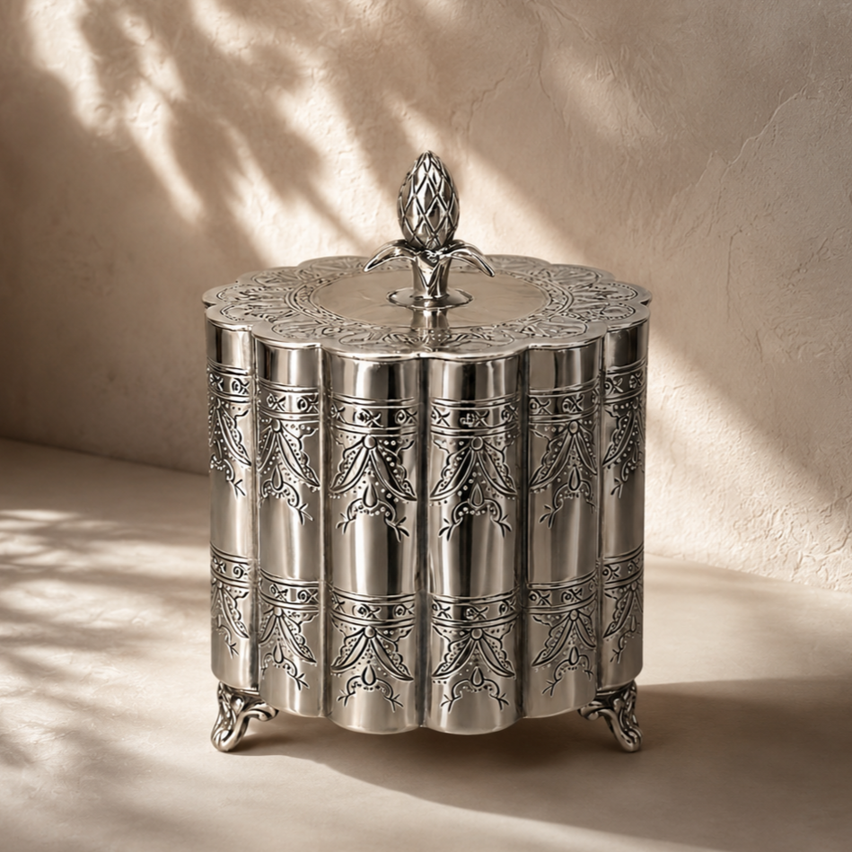 Antique silver keepsake box with embossed floral detailing, shown in use as a premium dry fruit gift box and decorative storage accent.