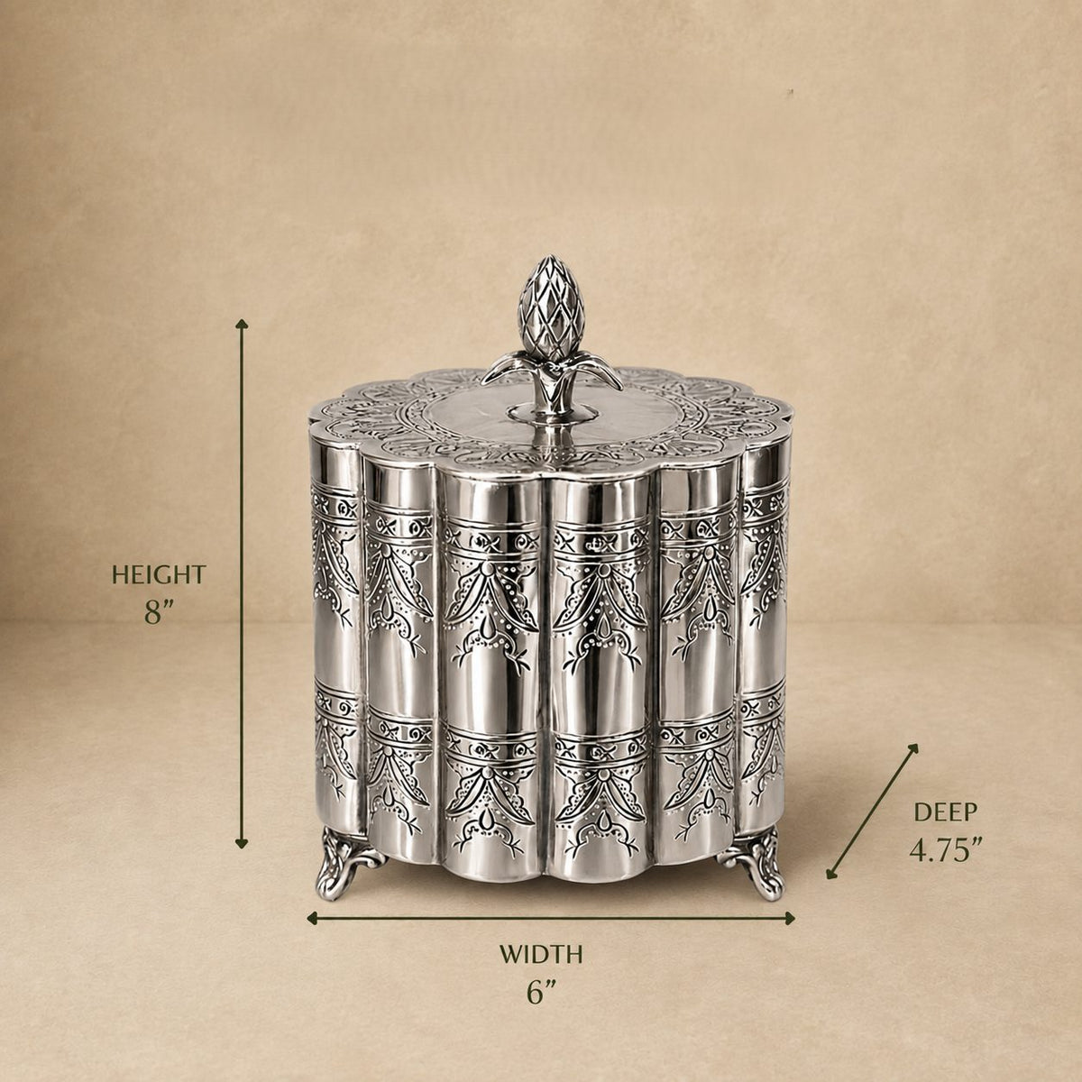Silver decorative metal storage box with engraved floral pattern and lid, dimensions 6 inches wide, 4.75 inches deep, and 8 inches high, displayed on a beige background.