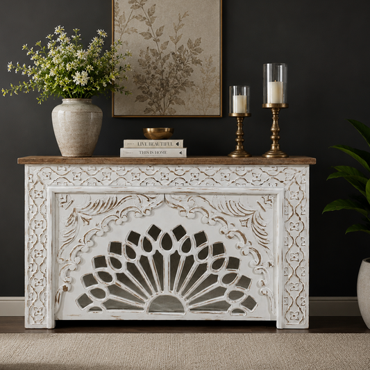 Handcrafted distressed white wooden console table with intricate floral carvings and a natural wood top, styled in a luxury living room against a dark wall.