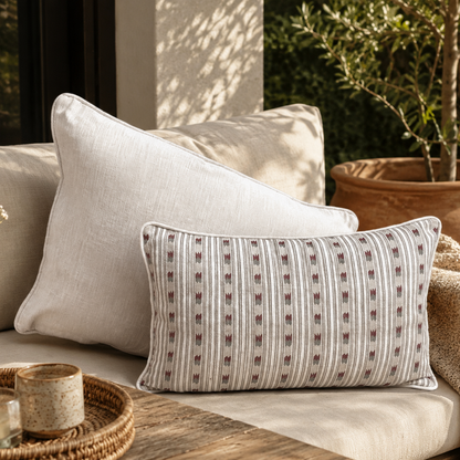 Beige striped linen cushion cover paired with a solid beige cushion on a luxury outdoor sofa, styled in a modern patio setting with natural textures and elegant home décor accents.