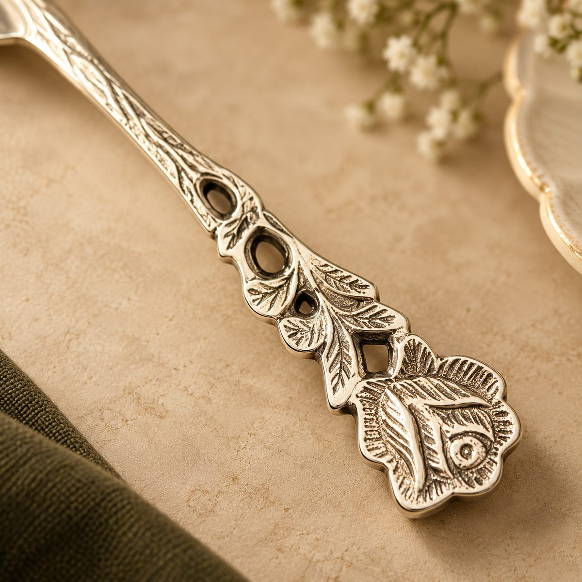 Close-up of the engraved rose and leaf detailing on a rose fruit fork handle.