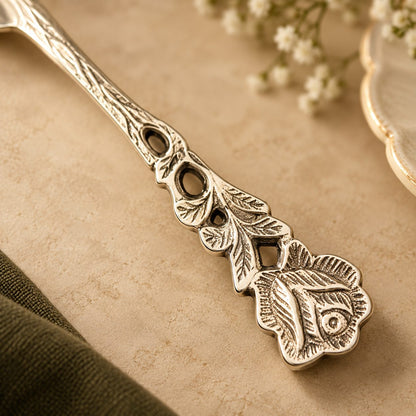 Close-up of the engraved rose and leaf detailing on a rose fruit fork handle.