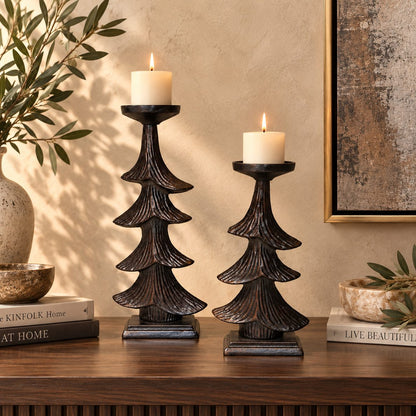 Rustic metal Christmas tree candle holder set styled with lit cream pillar candles on a luxury wooden console table.