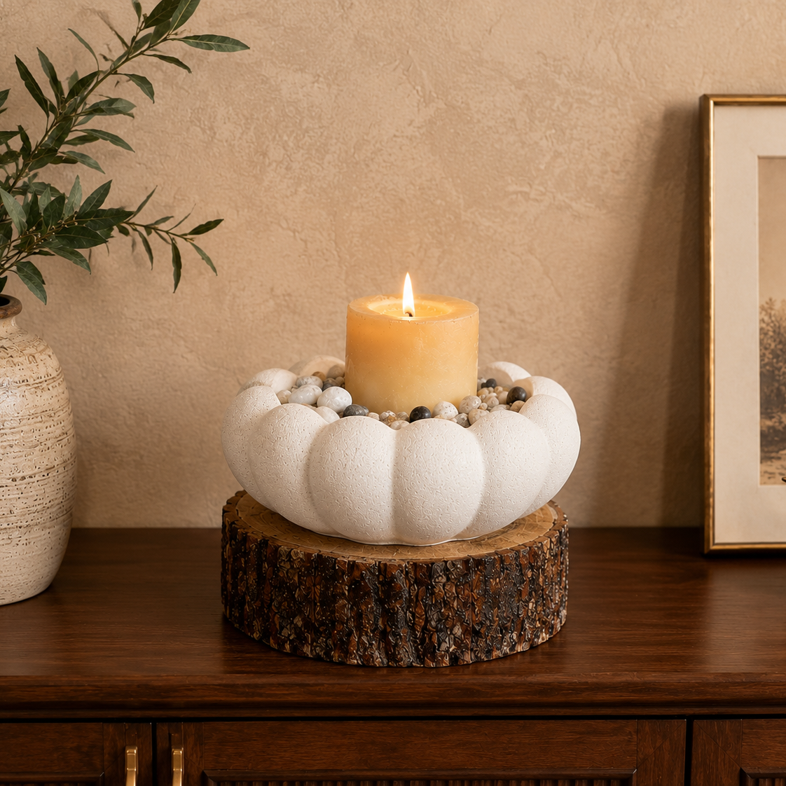 White scalloped ceramic bowl styled as a decorative candle centerpiece with natural pebbles on a wooden coffee table in a cozy living room.