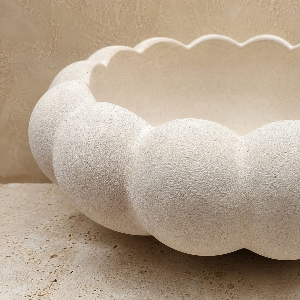 Close-up of a handcrafted white ceramic decorative bowl showcasing its elegant scalloped design and textured matte finish.