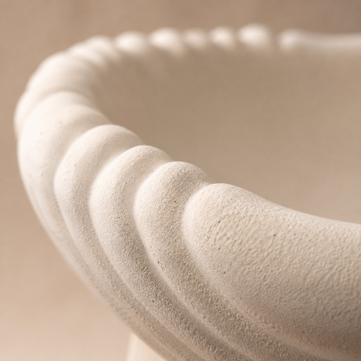 Close-up of the scalloped edge and sandstone-inspired matte texture of the white ceramic urli, highlighting premium craftsmanship.