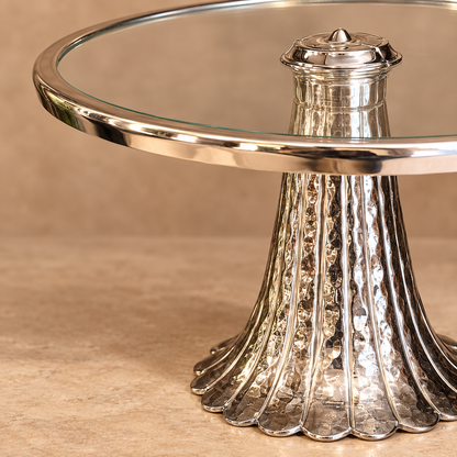 Close-up of the handcrafted aluminium pedestal base and elegant glass top of the silver serving stand.
