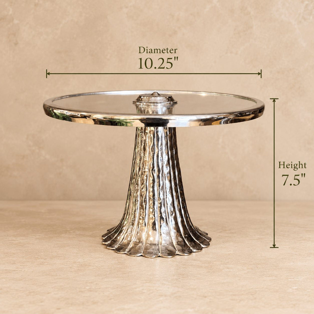 Dimensions of the silver pedestal serving stand with glass top measuring 10.25-inch diameter and 7.5-inch height.