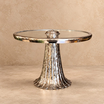 Front view of a handcrafted silver pedestal serving stand with an elegant glass top on a neutral studio background.