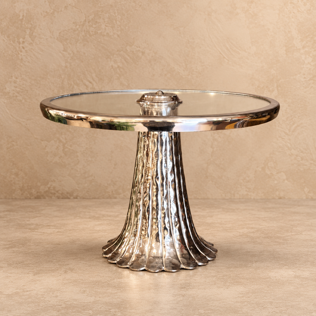 Front view of a handcrafted silver pedestal serving stand with an elegant glass top on a neutral studio background.