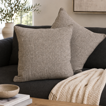 Taupe linen cushion covers styled on a dark charcoal sofa in a modern living room, adding a warm and elegant touch to contemporary home décor.