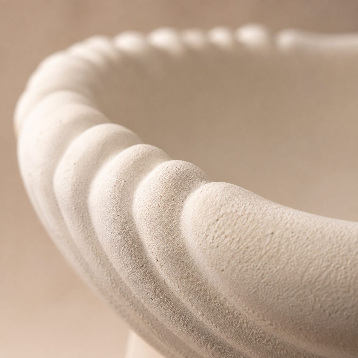 Close-up of the scalloped edge and sandstone-inspired matte texture of the white ceramic urli, highlighting premium craftsmanship.