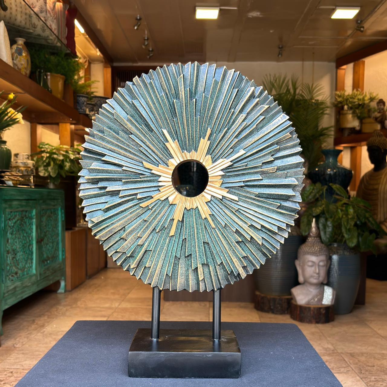 Blue and gold sunburst decorative sculpture with textured layers and open center on a black stand, ideal for modern home decor styling.